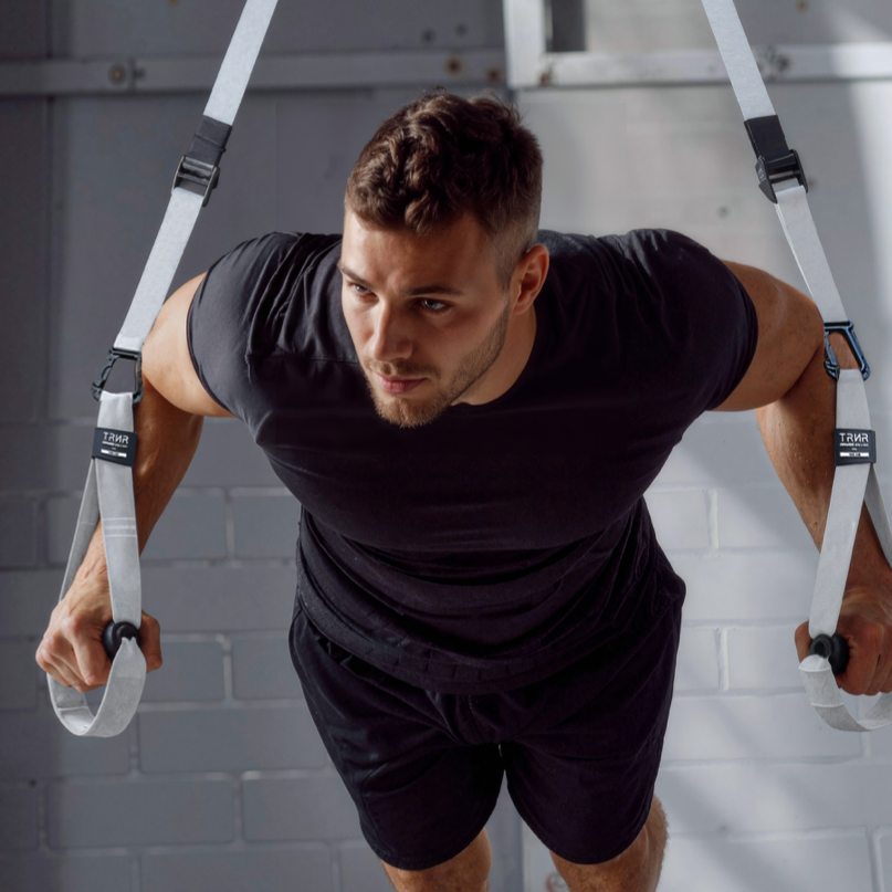 Man exercising using his own body weight with TRNR suspension straps